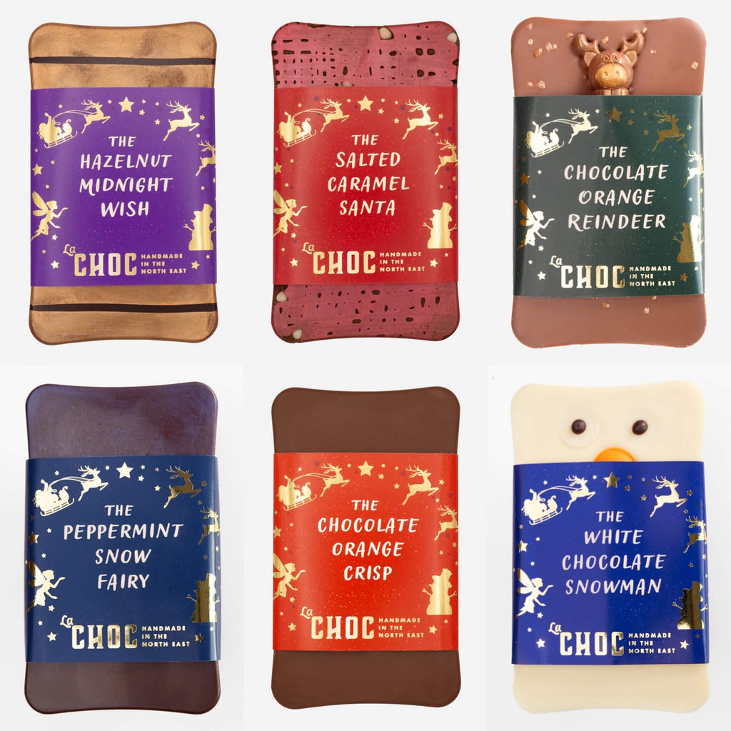 A festive bundle of six handmade Christmas chocolate bars from La Chocolatrice, including The Hazelnut Midnight Wish, The Salted Caramel Santa, The Chocolate Orange Reindeer, The Peppermint Snow Fairy, The Chocolate Orange Crisp, and The White Chocolate Snowman, perfect for gifting and seasonal indulgence.