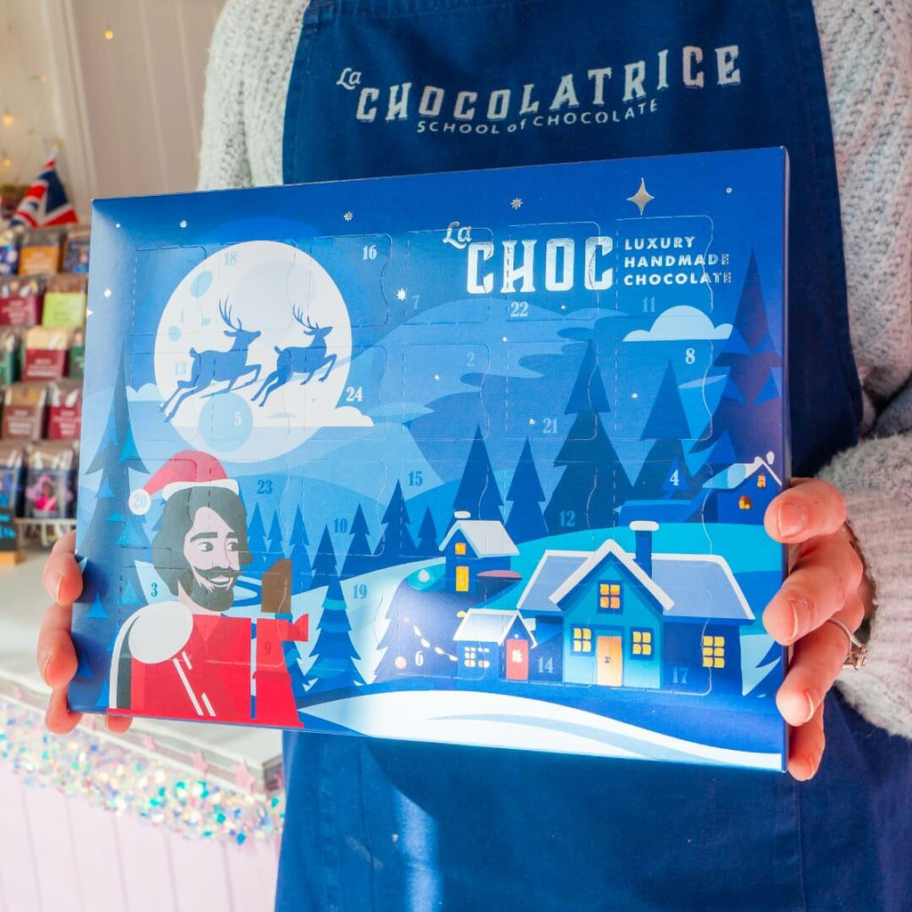 La Chocolatrice Christmas advent calendar box featuring festive winter design with Santa and snowy houses.