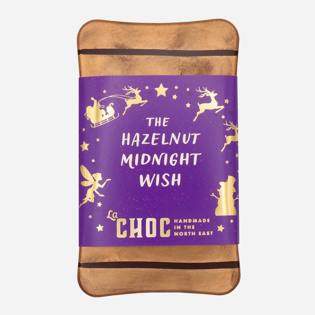 Handmade hazelnut milk chocolate bar from La Chocolatrice, wrapped in festive purple and gold packaging.