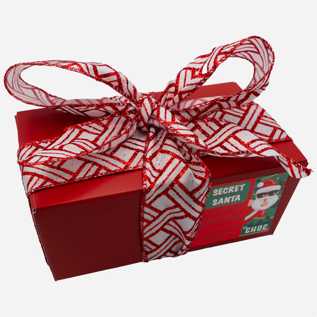 Red Secret Santa chocolate gift box from La Chocolatrice, tied with a red and white festive ribbon.